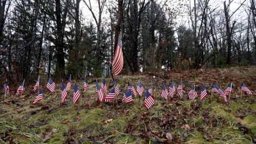 Flags on the side of Route 84 in Newtown honor the dead.