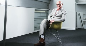 What does Wally Olin say about himself photographed in a stark room, in Corbusier glasses on an Eames chair?